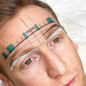 A male showing nano brow mapping.