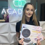 A student displaying her SMPU course completion certificate at Cosmetic Tattoo Clinic Manchester.