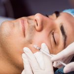 Man receiving anti-wrinkle injection on his face.