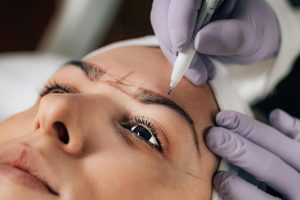 A woman having her eyebrows mapped ready for Microblading.