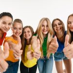 Female students putting their thumbs up for success after completing their Cosmetic Tattoos training.